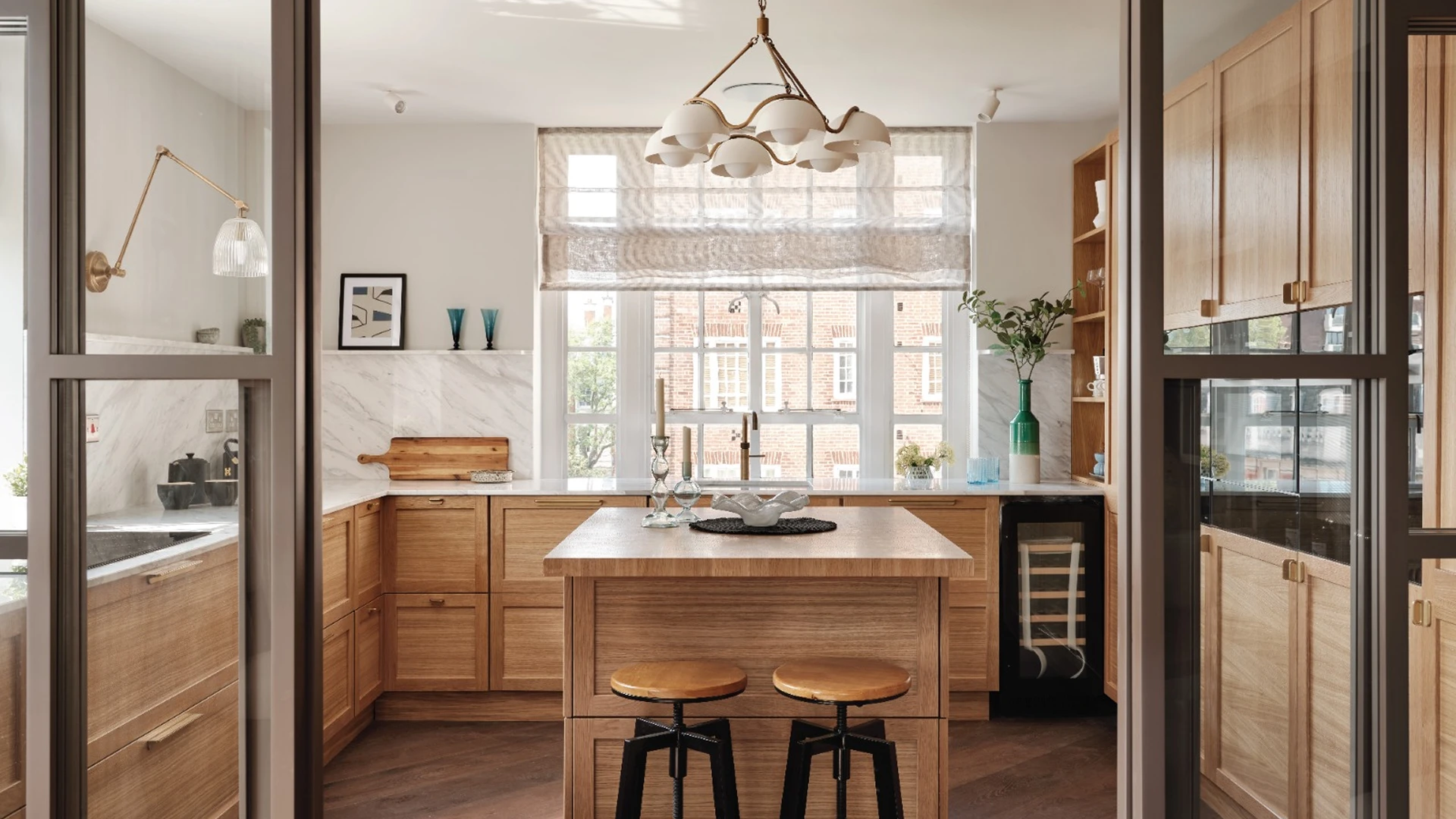 Luxury kitchen with light oak cabinetry and marble backsplash